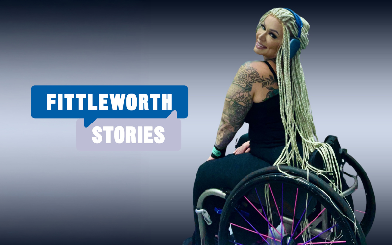 Michelle Moffat in her wheelchair with long braided hair and tattoos